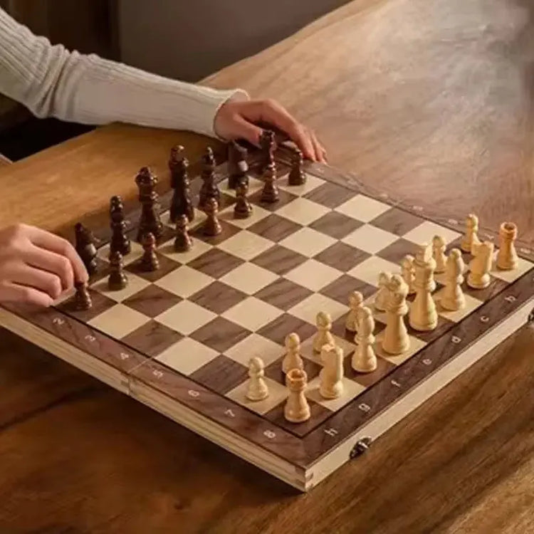 Person playing on a foldable travel chess set with wooden pieces on a stylish board.